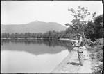Man Holding A Camera Standing At Lakeside by George French