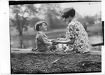 Young Boy And Girl Sitting On The Ground Holding Hands by George French