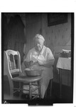 Seated Elderly Woman Snapping String Beans In The Kitchen by George French