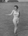 Woman Swimmer Standing Ankle-deep in Water at a Maine Beach by Maine Development Commission