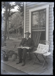 Empire Grove 39: Man on Cottage Porch with Newspapers, East Poland, ca. 1911