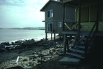 Storm damage to house on beach by Joseph Kelley